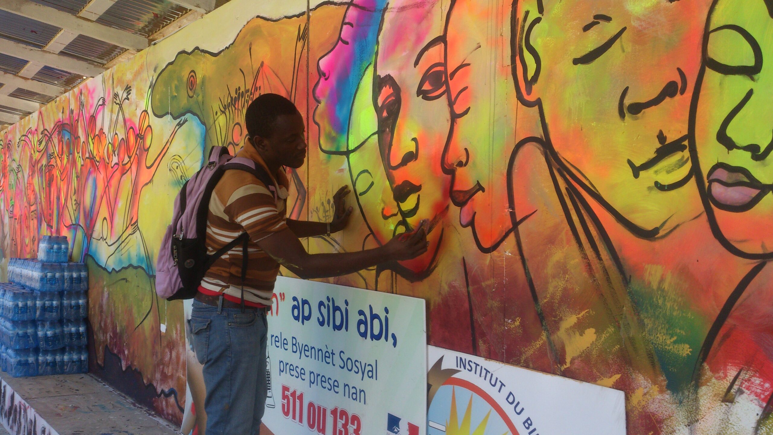 Bitho Faustin with a mural painting